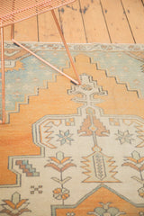 Distressed vintage Oushak rug detail with faded aqua blue, ivory, and dusty gold stepped motifs.