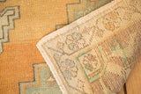 Vintage Oushak rug's distressed gold and aqua pile texture with hand-knotted reverse.