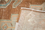 Distressed Oushak rug pile in bronze and teal, contrasting hand-knotted foundation.