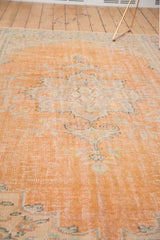 Distressed apricot Oushak rug showing even wear across knot heads and faded floral design.
