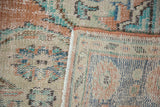 Distressed Oushak hand-knotted pile texture, showing knot heads, woven foundation, and secured edge.