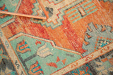 Distressed Vintage Oushak rug showcasing worn texture, vibrant burnt orange and mint green patterns.