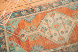 Distressed ivory medallion, featuring blossoms and combed stylization on orange.