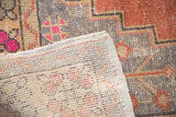 Distressed vintage Oushak rug displaying hand-knotted construction, short fringe, and worn pile.