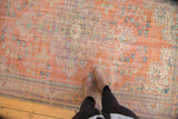 Distressed Oushak pile showcasing faded apricot field, rococo patterns, and time-softened texture.