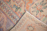 Hand-knotted Oushak rug's distressed pile and reverse showing vibrant orange, blue, and green hues.