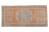 Vintage Distressed Oushak runner, dusty grapefruit red field, blue floral medallion, cloud band spandrels.