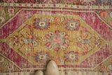 Distressed Oushak rug's gold oblong medallion, bright pink field, and visible foundation.