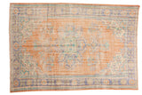 Distressed Oushak carpet, faded apricot and dusty blue floral medallion, visible wear and foundation.