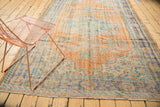 Vintage Oushak carpet displaying worn apricot, dusty blue, and mint green patterns.