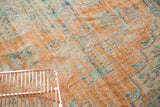 Distressed Oushak rug pile revealing worn knot heads, visible foundation, apricot, and blue.