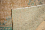 Hand-knotted foundation and distressed pale apricot pile of the vintage Oushak rug.