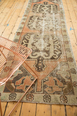 Distressed Oushak runner detail: time-softened peach, ivory, and charcoal stylized motifs.