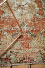 Distressed Oushak rug pile in cinnabar red, sage green, ivory, with visible knot heads and fringe.