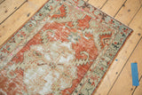 Distressed Oushak runner showing worn cinnabar red and light green border detail.