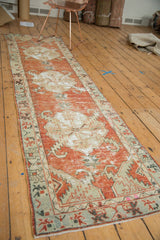 Distressed Oushak runner end with worn cinnabar red field and ivory sickle leaf patterns.