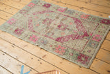Primitive geometric floral border detail on vintage Oushak rug in purple and pale blue.