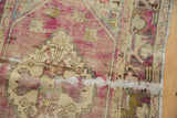Distressed vintage Oushak rug pile with worn texture, dusty purple, pale beige, and antique silvered patterns.