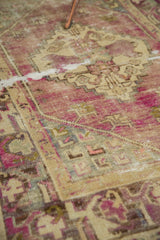 Distressed vintage Oushak rug pile with dusty purple, pale beige, and silver tones, showing mostly even wear.