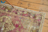 Distressed vintage Oushak rug corner, with meandering floral border, dusty purple, and beige.
