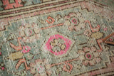 Distressed vintage Oushak rug texture with bubblegum pink and slate blue geometric motifs.