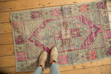 Distressed vintage Oushak rug, elongated medallion in purple, pink, pale blue, even wear.