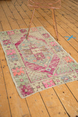 Distressed pile and original selvage of a vintage Oushak rug, featuring magenta and pastel motifs.