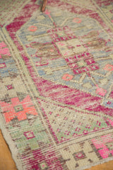 Worn pile of an Oushak rug, highlighting fuchsia, pale blue, and ivory tones.