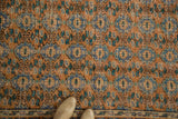Distressed Oushak rug pile with terra cotta, sky blue floral guls, border, and shoe.