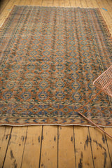 Distressed Oushak carpet with terra cotta rust, blue diamond border and low pile.