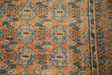 Textured terra cotta Oushak carpet with blue and green floral guls and geometric border details.