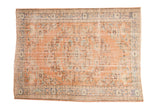 Vintage distressed Oushak rug in faded apricot, blue, and ivory with a shadow medallion.