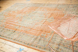 Worn pile texture of a vintage distressed Oushak rug, showing pale terra cotta and celadon.