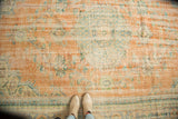 Distressed Oushak carpet texture with even wear, light foundation, pale terra cotta, and faded blues.