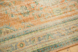 Distressed vintage Oushak carpet pile showing worn texture, faded terra cotta, green, and blue.
