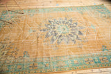 Distressed apricot Oushak rug corner with mint green border and serrated spandrel details.