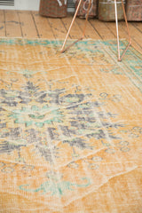Distressed vintage Oushak rug with faded apricot, mint green, and visible foundation wear.