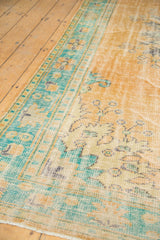 Distressed vintage Oushak rug corner, with faded apricot field and mint green border.