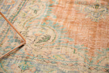 Close-up of distressed Oushak rug pile with visible foundation, subtle rococo patterns, and faded colors.