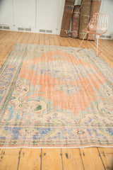 Fringe and worn border of a blush rose and blue vintage distressed Oushak rug.