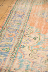 Distressed vintage Oushak rug pile with even wear, featuring faded rose, blue, and mint.