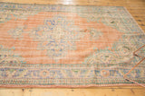 Faded royal blue and blush rose distressed texture on vintage Oushak rug corner.
