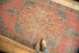 Distressed vintage Oushak runner with cinnabar red field, rams horn motif, and serpent border.