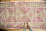 Overhead view of a distressed Oushak runner with repeating geometric medallions and a soft, even patina.