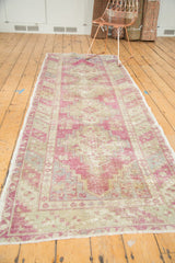 Distressed Oushak runner with dusty purple medallions, shown at a three-quarter perspective.