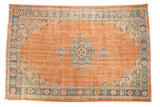 Distressed Vintage Oushak Carpet with apricot orange field, ornate scalloped medallion, and dusty mint green details.