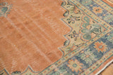 Distressed hand-knotted vintage Oushak rug with apricot field, scalloped contour, and blue green borders.