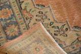 Textured pile and original intact selvage of a distressed vintage Oushak rug.