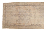 Distressed vintage Oushak carpet with faded medallion, vinery, and subtle neutral tones.