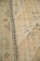 Vintage distressed Oushak pile showing even wear, visible foundation, and geometric border.